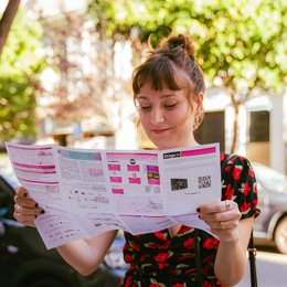 Archivo - Espectadora revisando la programación, Russafa Escènica - Festival de Tardor 2024.