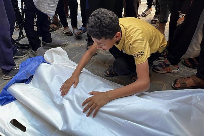 Un palestino junto a los cadáveres de varios muertos por un ataque de Israel contra un punto de recogida de agua en el campamento de Nuseirat, en la Franja de Gaza (archivo)