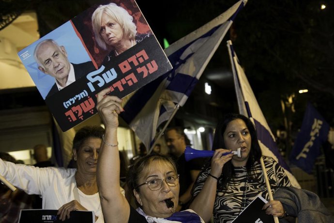Archivo - 20 de novembro de 2024, Israel, Tel Aviv: Um manifestante ergue um cartaz com imagens do primeiro-ministro israelense Benjamin Netanyahu e do procurador-geral de Israel Gali Baharav-Miara durante uma manifestação do lado de fora da casa do procu