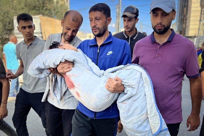 July 13, 2025, Nusairat, Gaza Strip, Palestinian Territory: Palestinians mourn by the bodies of relatives who were killed in Israeli strikes targeted a water filling station, at the Al-Awda hospital, in Nusairat refuge camp, central Gaza Strip, on July 13