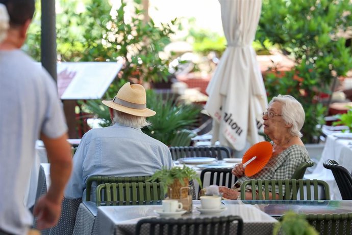 Dos personas se refrescan en una terraza en Madrid