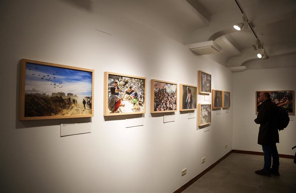 Archivo - Una persona observa fotografías expuestas durante la entrega del 28 Premio Internacional Luis Valtueña, a 30 de enero de 2025.