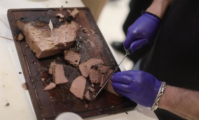 Archivo - Un camarero corta carne en un stand durante el día de apertura de Madrid Fusión 2021