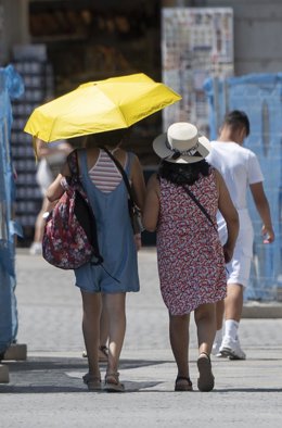 Archivo - Dos personas caminan con paraguas en una calle de Madrid