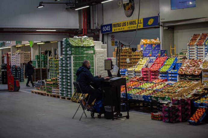 Archivo - Un hombre trabaja frente a un puesto de frutas en Mercabarna, en Barcelona, Catalunya (España), a 9 de diciembre de 2020. 