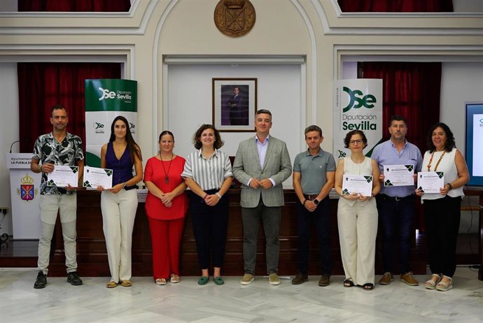 Foto de familia de la jornada de clausura donde asisten el vicepresidente de Prodetur, Rodrigo Rodríguez (5i), y la alcaldesa de La Puebla del Río, María Dolores Prósper (4i) para entregar diplomas.
