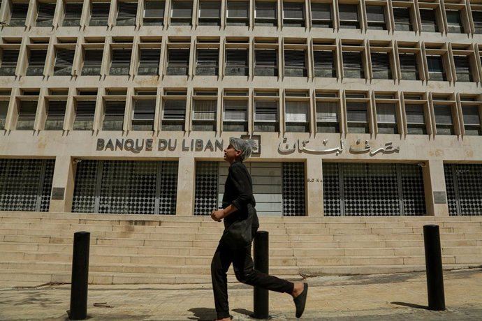 Archivo - Un hombre camina frente a la sede del Banco Central de Líbano en Beirut (archivo)