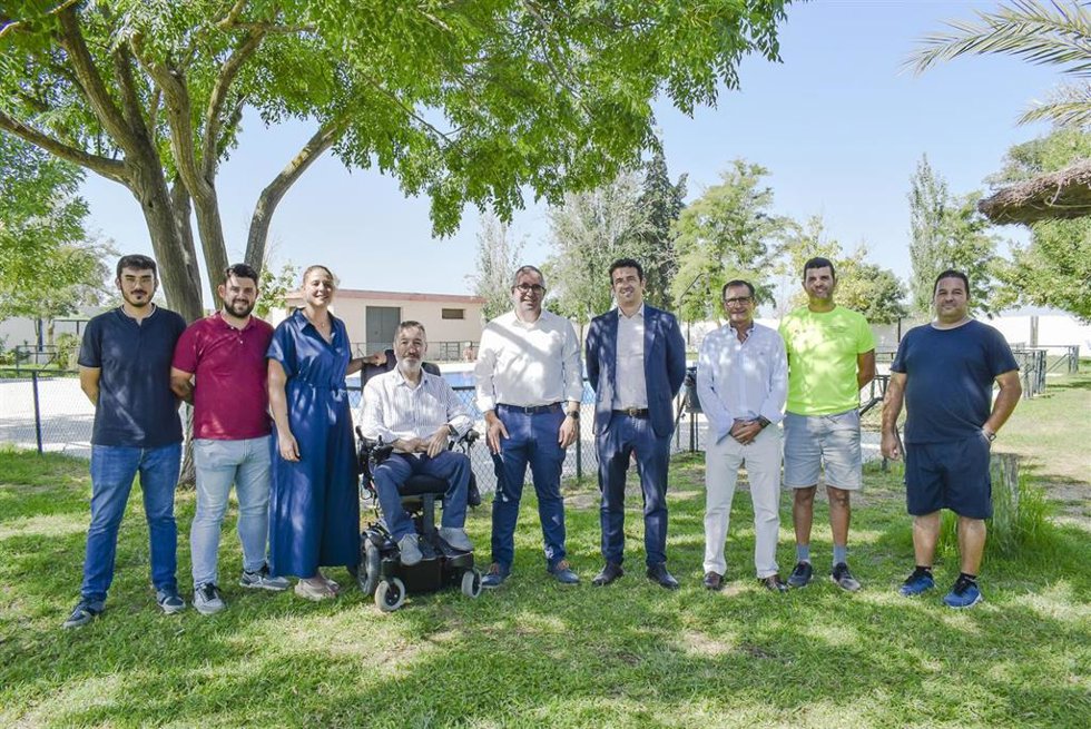 El alcalde de Los Palacios y el director general de UNEI, con las siete personas con discapacidad contratadas en las piscinas municipales de la localidad y sus pedanías.