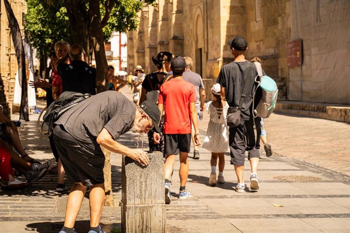 Archivo - Turistas se refrescan con agua para hacer frente a las altas temperaturas, en una imagen de archivo.