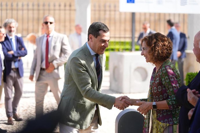 El presidente de la Junta, Juanma Moreno, saluda a la vicepresidenta primera y ministra de Hacienda, María Jesús Montero, en el acto de inicio de las obras del subtramo III de la Línea 3 de metro de Sevilla. (Foto archivo del 20 de junio de 2025).