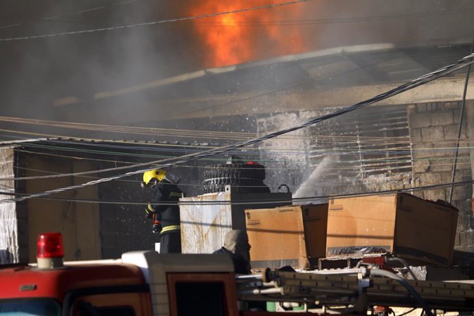 Archivo - BAGHDAD, Oct. 28, 2024  -- A firefighter works at a fire site near a warehouse in Baghdad, Iraq on Oct. 27, 2024. A fire broke out at a warehouse in Iraqi capital Baghdad on Sunday.