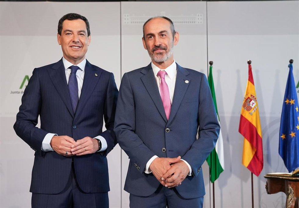 El presidente de la Junta de Andalucía, Juanma Moreno (i), y el nuevo rector de la Universidad de Huelva, José Rodríguez Quintero.