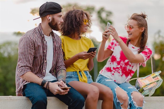 Archivo - Amigos utiilzando un 'smartphone'.
