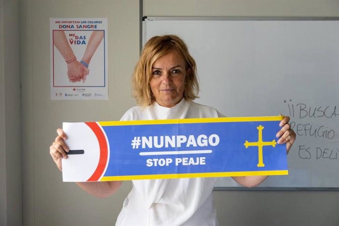 La diputada del Grupo Mixto y portavoz de Somos Asturies, Covadonga Tomé, con un cartel reivindicativo para no pagar el peaje del HUerna.