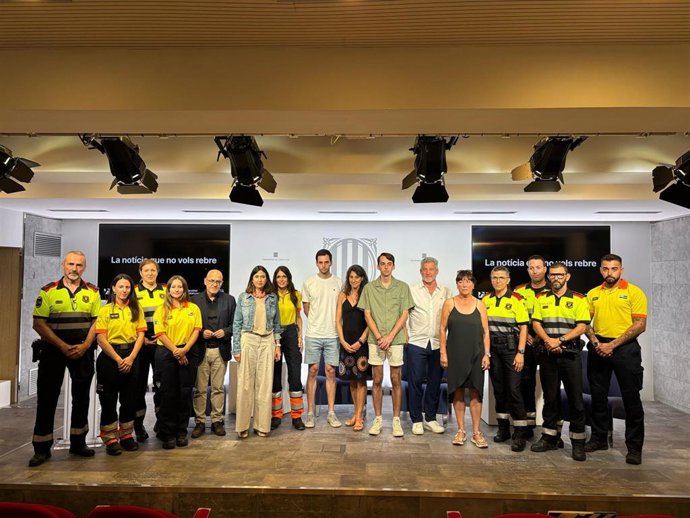 La consellera de Interior, Núria Parlon, y el director del Servei Català de Trànsit, Ramon Lamiel, junto a efectivos de Mossos y del SEM con familiares de víctimas mortales de accidentes de tráfico que han participado en la campaña