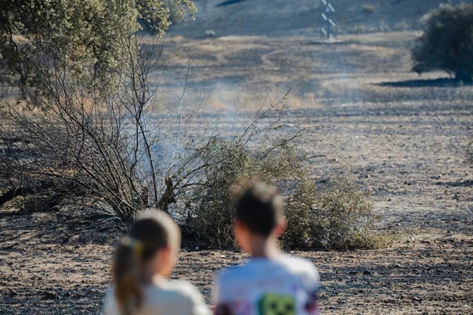 Dos niños observan restos del incendio que se originó ayer en Méntrida, a 18 de julio de 2025, en Méntrida, Toledo, Castilla-La Mancha (España).
