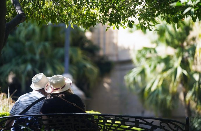 Dos personas con ropa veraniega y sombreros.A 18 de julio de 2025, en Málaga (Andalucía, España). 