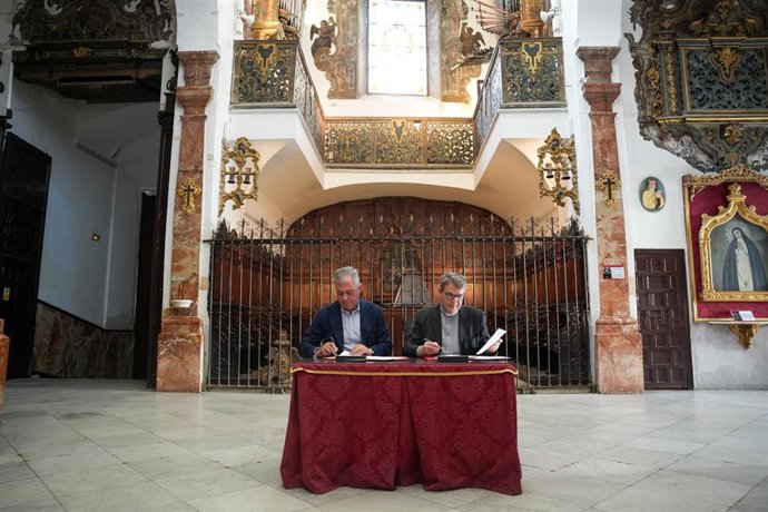 Sanz y el párroco de San Nicolás y Santa María la Blanca en la firma del convenio