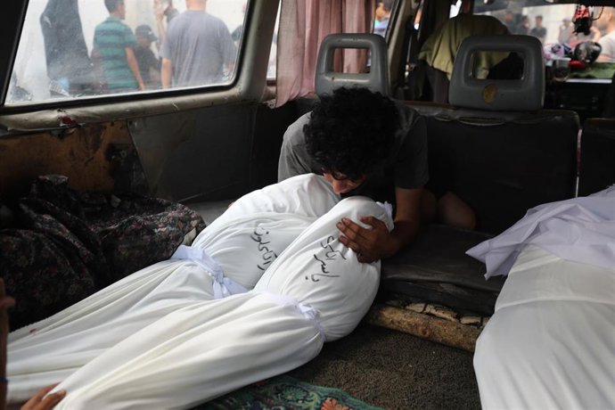 Un palestino junto a varios muertos por un bombardeo del Ejército de Israel contra tiendas de campaña usadas por desplazados en la ciudad de Gaza, en el norte de la Franja de Gaza (archivo)