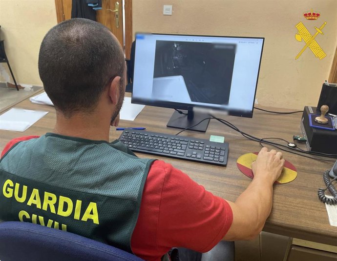 Un agente de la Guardia Civil analiza las imágenes de una cámara de seguridad en el marco de la investigación en Roquetas de Mar (Almería).