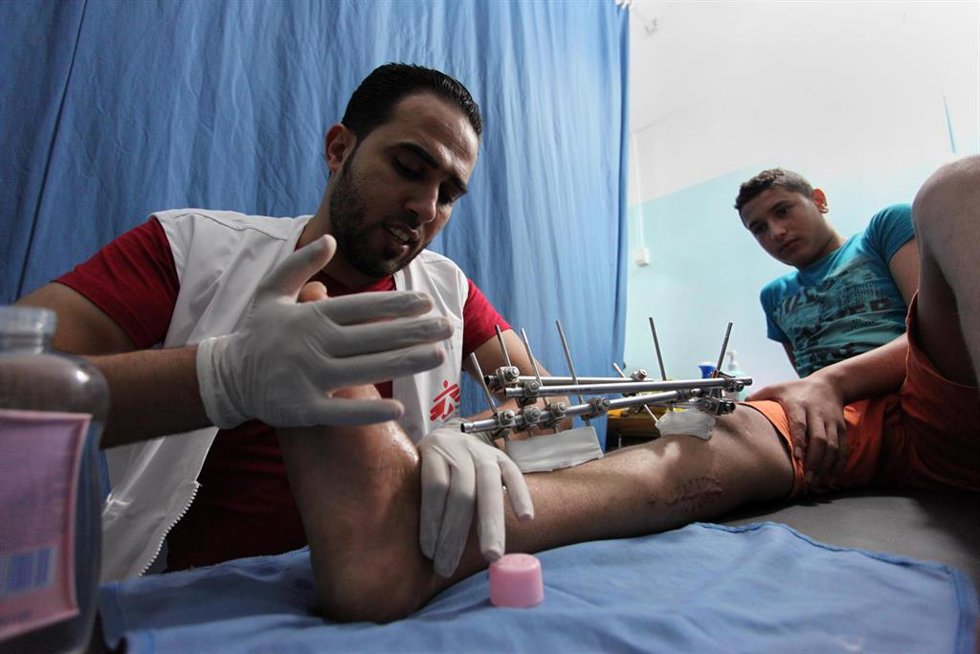 Archivo - Un sanitario de Médicos Sin Fronteras atiende a un joven herido por las tropas israelíes en Gaza (archivo)