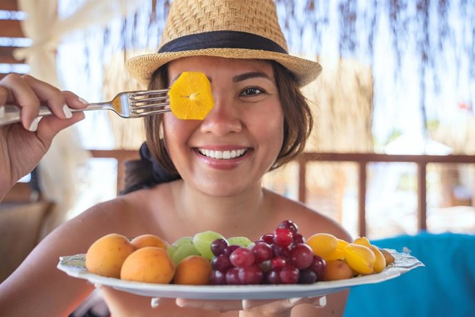 Archivo - Mujer comiendo frutas en verano.