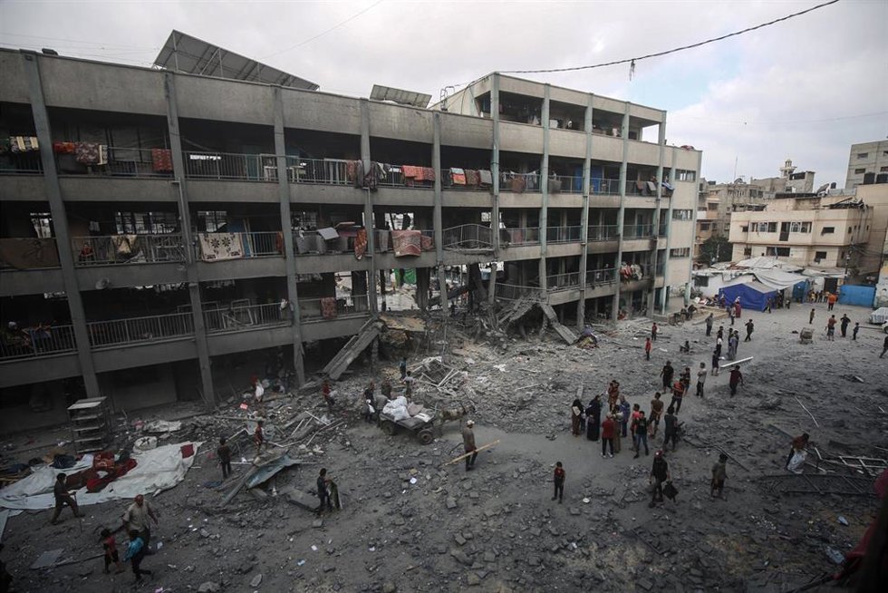 Palestinos entre las ruinas de la escuela Al Falá de la ciudad de Gaza tras un ataque de Israel contra el centro, situado en el norte de la Franja de Gaza (archivo)
