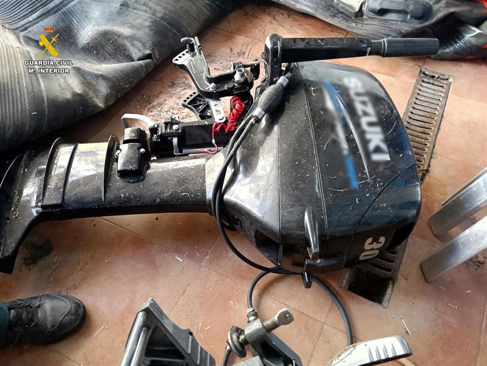 Uno de los motores intervenidos por la Guardia Civil junto a la embarcación incautada en una playa de Mojácar (Almería).