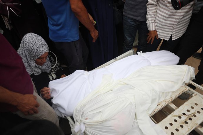 21 de julho de 2025, Territórios Palestinos, Gaza: Pessoas em luto rezam perto dos corpos de palestinos mortos em ataques israelenses durante a noite, de acordo com médicos, durante o funeral no Hospital Al-Shifa na Cidade de Gaza. Foto: Omar Ashtawy/APA 