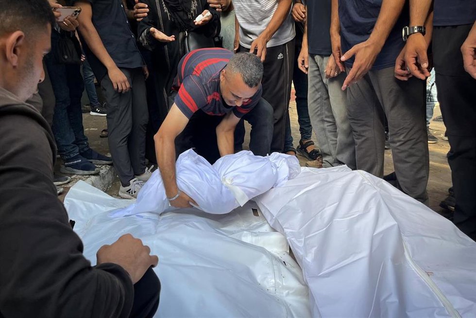 Palestinos junto a varios muertos por los ataques del Ejército de Israel contra la Franja de Gaza (archivo)