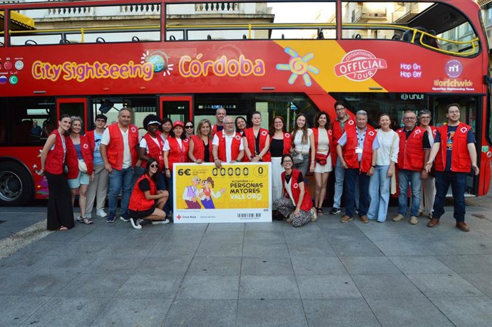 Miembros de Cruz Roja en Córdoba junto a la imagen del boleto del Sorteo de Oro.