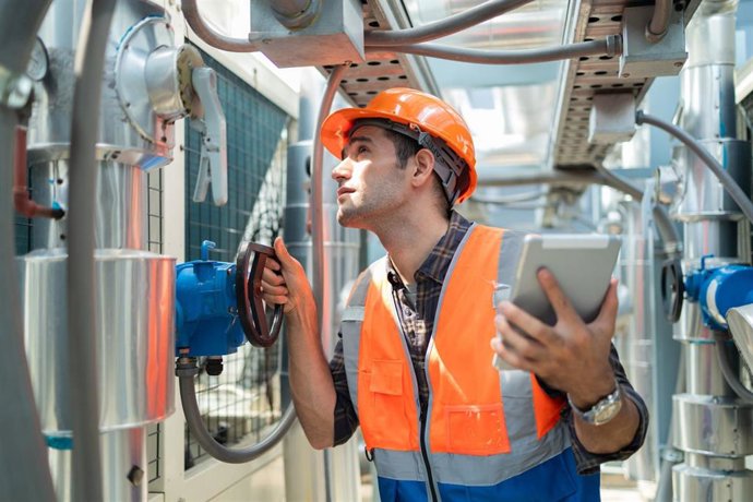 Archivo - Ingeniero comprueba las válvulas para asegurar la cantidad apropiada de agua que fluye en las tuberías del aire acondicionado.