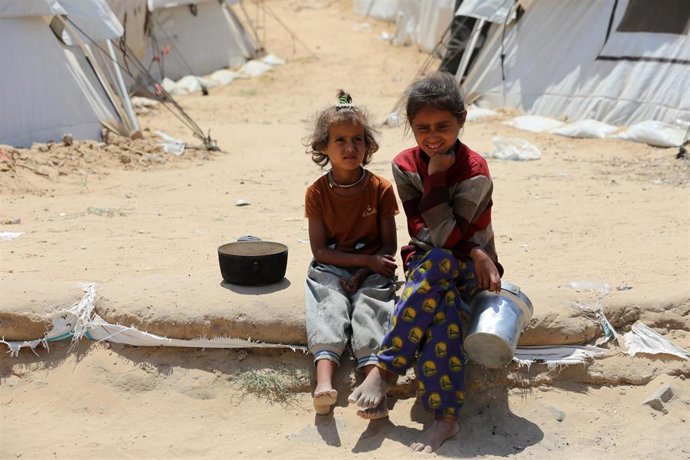 Archivo - Niños palestinos esperan una entrega de alimentos por parte de una organización caritativa en la ciudad de Gaza, en el norte de la Franja, en medio de la ofensiva de Israel y las restricciones a la entrada de ayuda humanitaria (archivo)