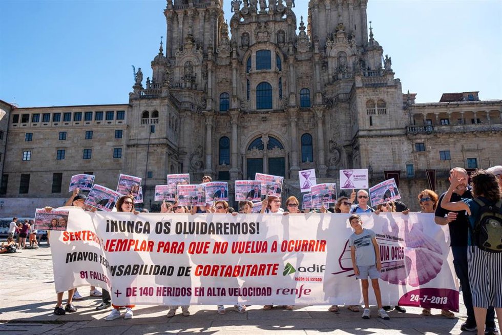 Archivo - Varias personas con una pancarta y carteles durante una concentración de las víctimas de Angrois, frente a la Catedral de Santiago, a 24 de julio de 2024, en Santiago de Compostela, A Coruña, Galicia (España). Víctimas del accidente del tren A