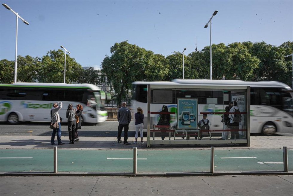 Archivo - Varias personas esperan en una parada de autobús 