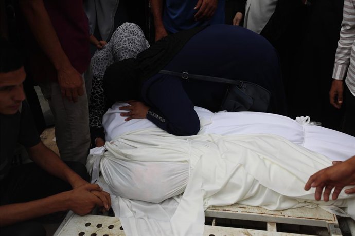 21 July 2025, Palestinian Territories, Gaza: Mourners pray near the bodies of Palestinians killed in overnight Israeli strikes, according to medics, during the funeral at Al-Shifa Hospital in Gaza City. Photo: Omar Ashtawy/APA Images via ZUMA Press Wire/d