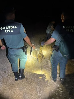 Dos agentes de la Guardia Civil con dos ejemplares capturados de manera furtiva.