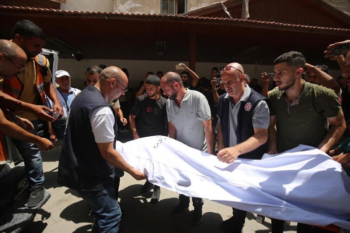 Palestinos junto a un muerto a causa del ataque ejecutado por Israel contra la única iglesia católica de la Franja de Gaza, la Iglesia de la Sagrada Familia de la ciudad de Gaza (archivo)