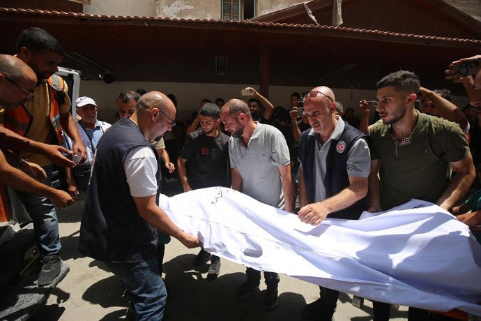 17 de julho de 2025, Territórios Palestinos, Cidade de Gaza: Pessoas em luto palestinas levam o corpo de um ente querido para o enterro no Arab Ahli, também conhecido como Hospital Batista, após um ataque israelense anterior à Igreja da Sagrada Família. F