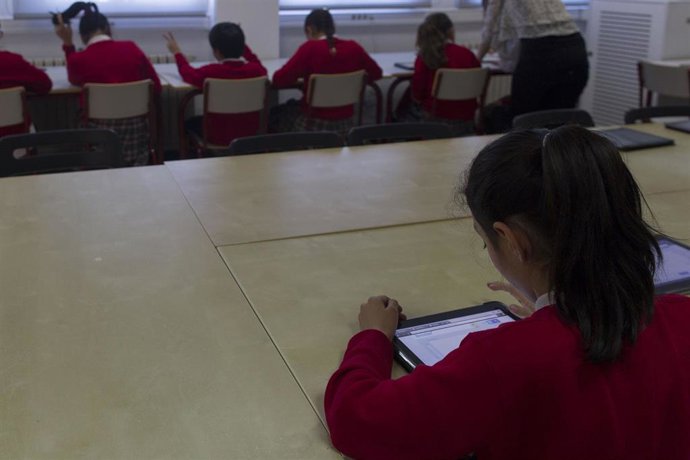 Archivo - Imagen de una niña con un dispositivo electrónico en Madrid en un aula