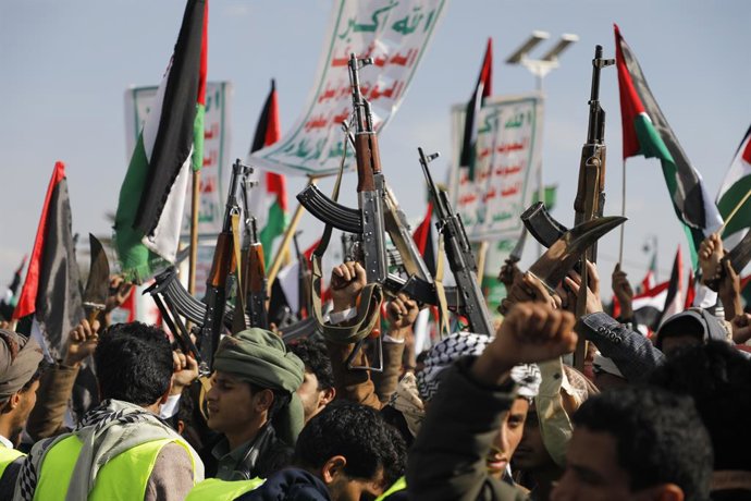 Archivo - January 5, 2024, SANAA, Sanaa, Yemen: January 05, 2024, Sanaa, Yemen: A people hold up guns, wave a Palestinian flag and chants slogans during demonstrate to commemorate ten Houthi fighters killed by the U.S. Navy in the Red Sea, amid the ongoin