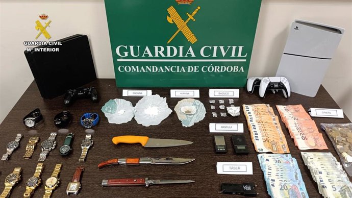 Droga, armas blancas, dinero y relojes, entre otros efectos, intervenidos por la Guardia Civil al desmantelar un punto de venta de drogas en Aguilar de la Frontera.