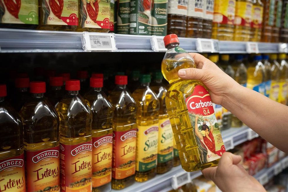 Archivo - Una persona sostiene una botella de aceite, en Barcelona.