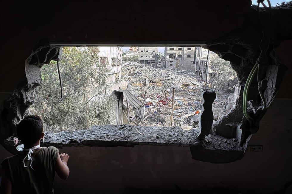Algunos palestinos inspeccionan los escombros de una vivienda familiar destruida por ataques aéreos israelíes en Al Zawaida, en el centro de la Franja de Gaza (archivo)