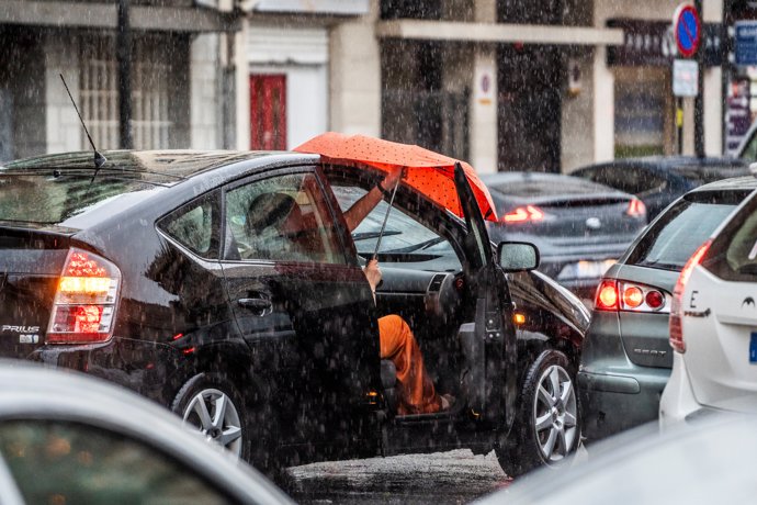 Archivo - Una se sube a un coche bajo la lluvia, a 3 de julio de 2023, en Valencia, Comunidad Valenciana (España). La Agencia Estatal de Meteorología (Aemet) ha activado la alerta amarilla en Valencia por lluvias y tormentas y la naranja en Castellón. Los