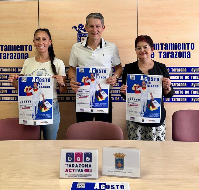 El concejal de Comercio de Tarazona, José Antonio Docando, y dos representantes de la Asociación de Comercio, Servicios e Industria (ACT) presentan el cartel de la campaña 'Agosto en blanco'.