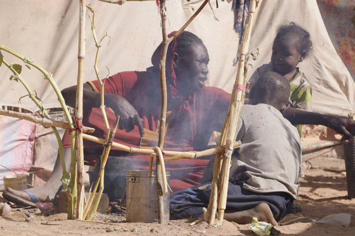 EL FASHER (SUDAN), July 11, 2025  -- A woman prepares food for children at a displacement camp in El Fasher, North Darfur region, Sudan, on July 9, 2025. The United Nations Children's Fund (UNICEF) said Friday that the number of children suffering from se