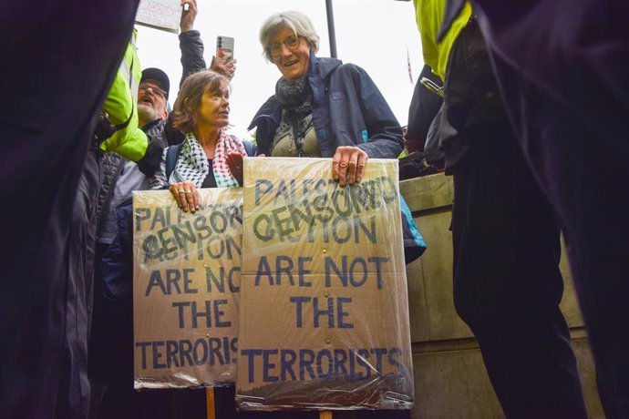 July 19, 2025, London, England, United Kingdom: Police officers arrest a pair of protesters in Whitehall who were holding placards stating 'Palestine Action are not the terrorists', with the word 'Censored' covering 'Palestine Action'. Thousands of people