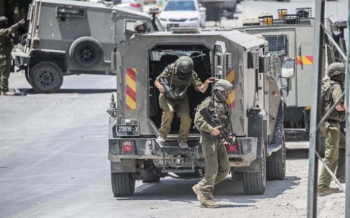 23 de julho de 2025, Nablus, Cisjordânia, Palestina: Soldados israelenses saem de seus veículos militares para invadir um prédio durante uma incursão na cidade para prender um palestino procurado, suspeito de ser responsável pelos atentados a ônibus em Te