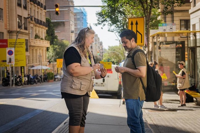 Una informadora explica a un ciudadano el cambio en la calle Amigó de Barcelona.